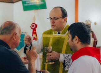 Czy można przyjąć komunię świętą dwa razy w ciągu jednego dnia? Ksiądz udzielający komunii świętej mężczyznom w kościele